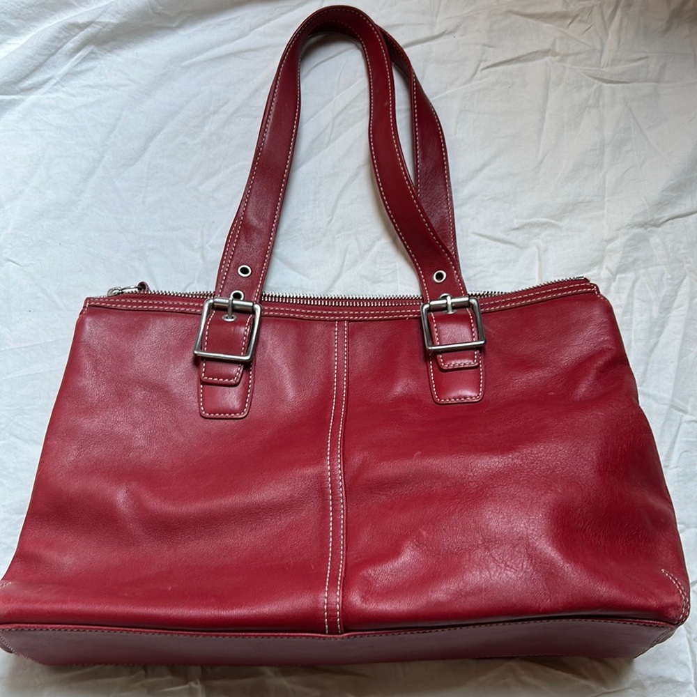 Red leather Coach shoulder bag with metal handle clasps and contrast stitching